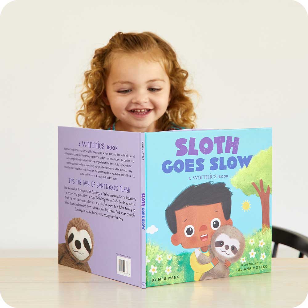 Image 93: Toddler smiling while reading Sloth Goes Slow Book - Warmies USA