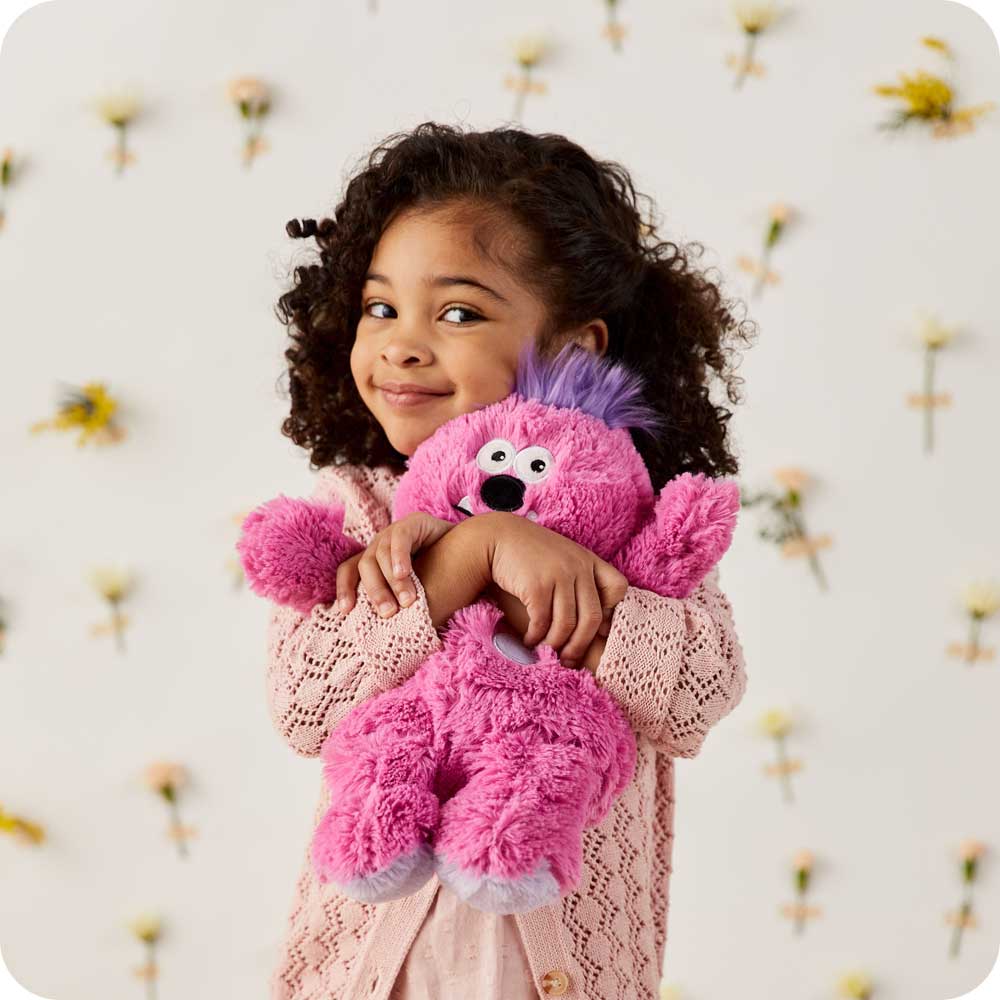 Image 103: Little girl hugging her Cute Weighted Lavender Scented Pink Monster Stuffed Animal Heating Pad Warmies