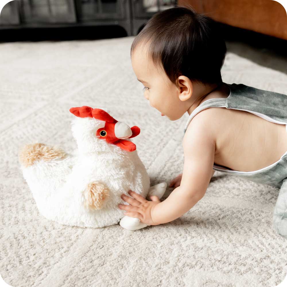 Image 105: Baby playing with Soft Warm Weighted Chicken Plush Warmies