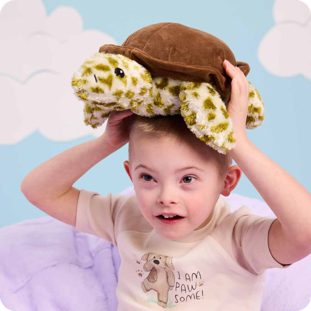 Image 105: Little boy holding a Turtle Warmies on his head.