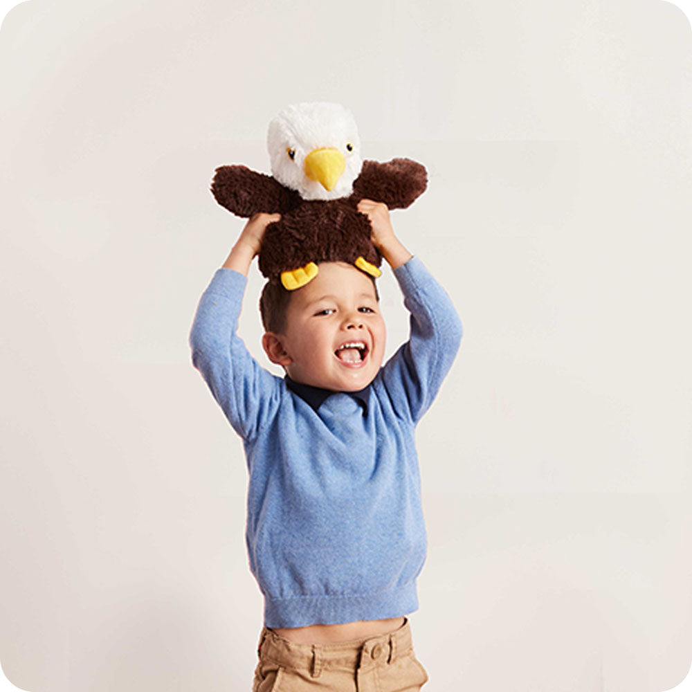 Image 103: boy holding an eagle stuffed animal on his head